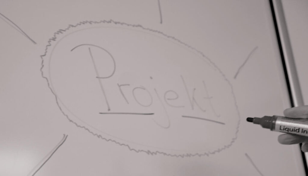 Auf einem Whiteboard steht das Wort Projekt.