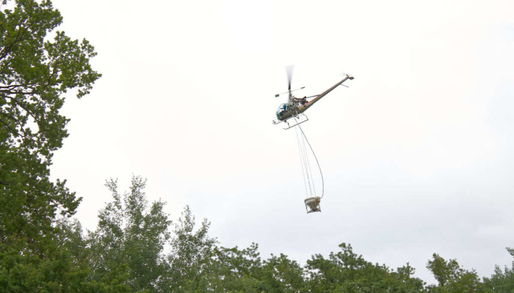 Hiller-Maschine fliegt mit Applikationskübel.
