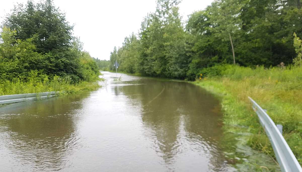 Hochwasser überschwemmt eine Landstraße.