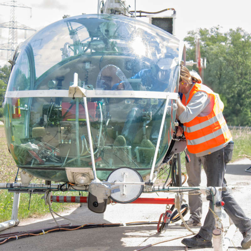 Ein KABS-Mitarbeiter spricht mit einem Hubschrauber-Piloten.