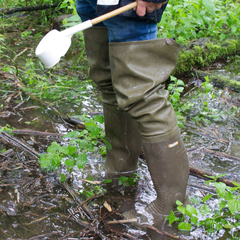 Ein KABS-Mitarbeiter steht in einer überschwemmten Brutstätte.